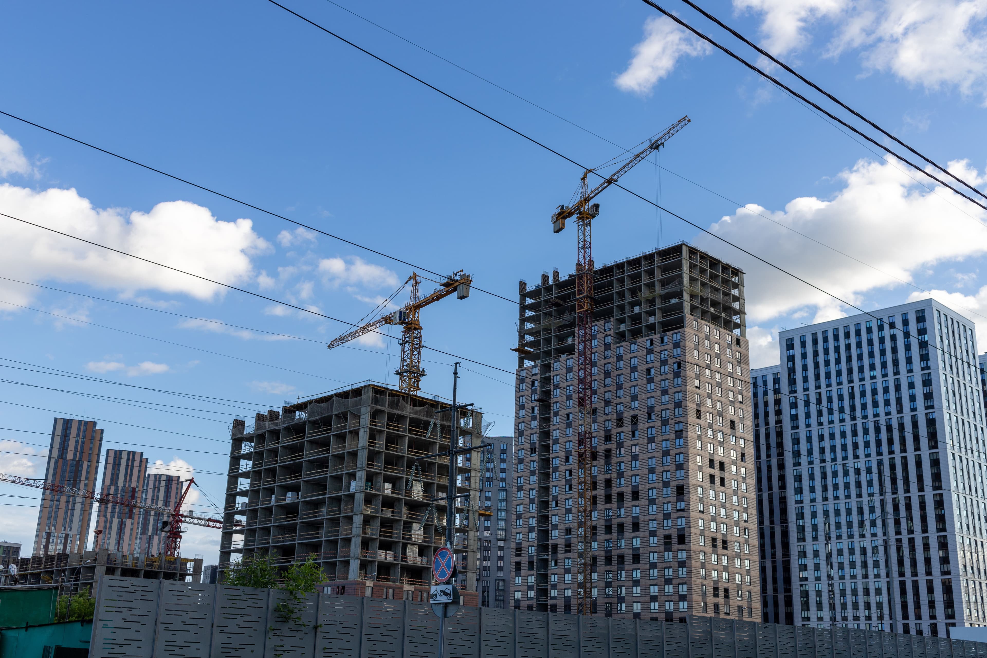 Commercial high-rise buildings under construction against a blue sky